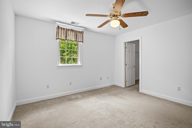 carpeted spare room featuring ceiling fan