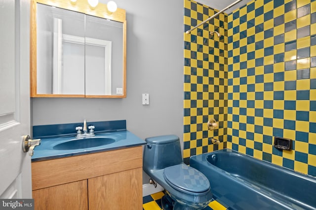 full bathroom featuring vanity, tiled shower / bath combo, and toilet