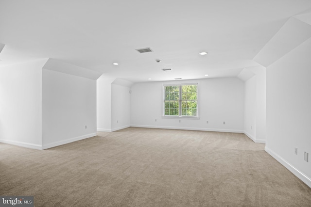 empty room with light colored carpet and lofted ceiling