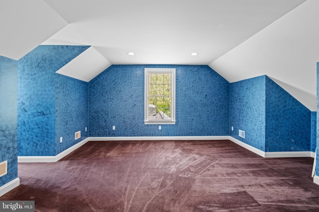 bonus room with vaulted ceiling and carpet floors