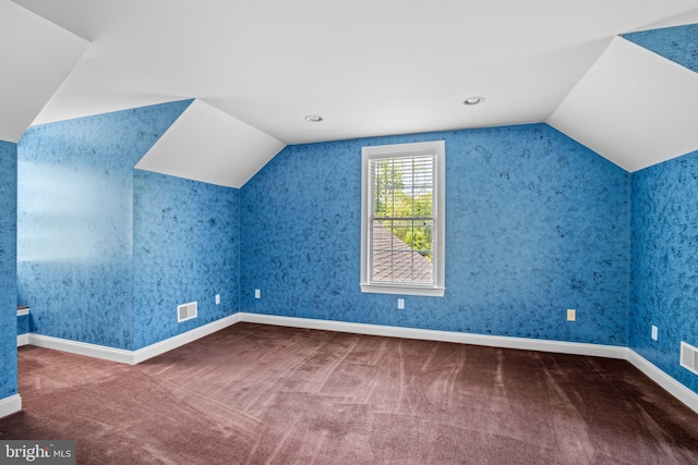 bonus room with vaulted ceiling and carpet