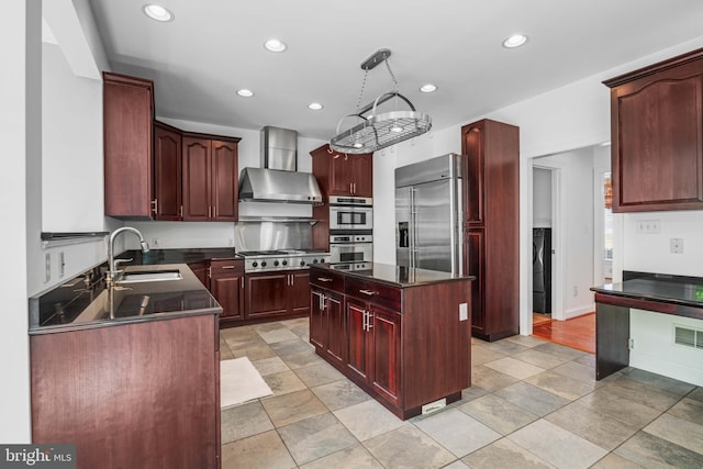 kitchen with a kitchen island, appliances with stainless steel finishes, light tile flooring, wall chimney range hood, and sink