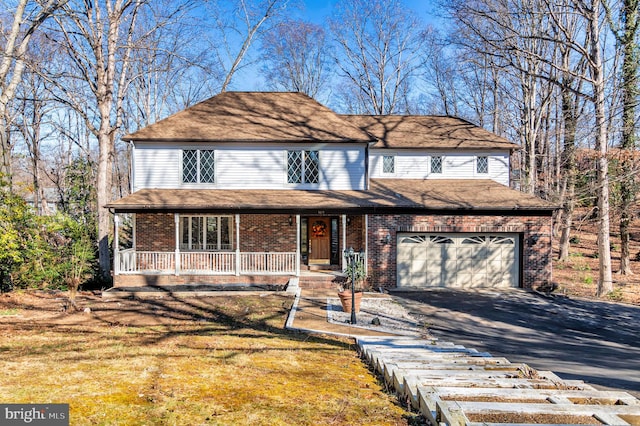 front facade featuring covered porch and a garage