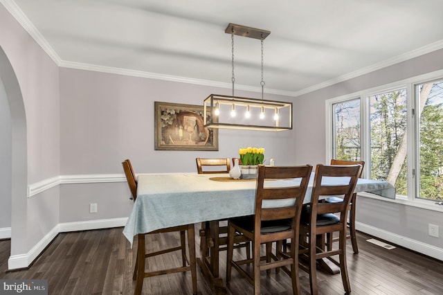 dining area featuring ornamental molding and dark hardwood / wood-style flooring