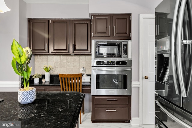 kitchen featuring appliances with stainless steel finishes, dark stone countertops, tasteful backsplash, and light tile patterned floors