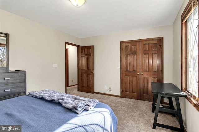 bedroom with a closet, light carpet, and multiple windows