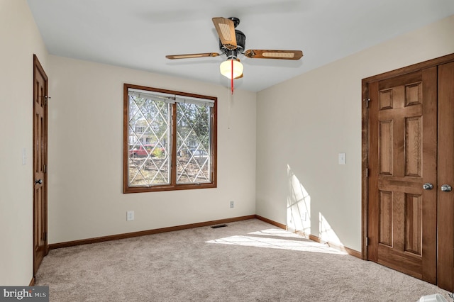 unfurnished room featuring light colored carpet and ceiling fan