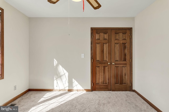 empty room featuring light carpet and ceiling fan