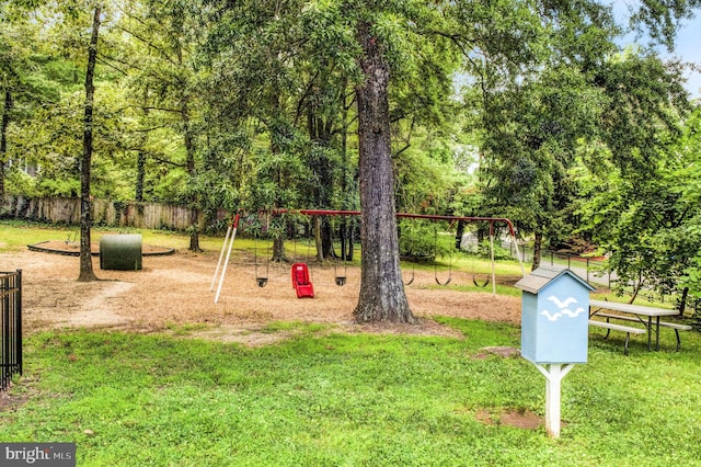 view of home's community with a playground and a yard