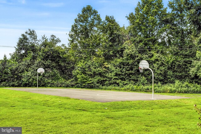 view of sport court featuring a lawn