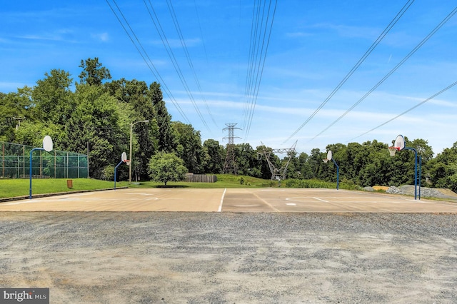 view of sport court with a lawn