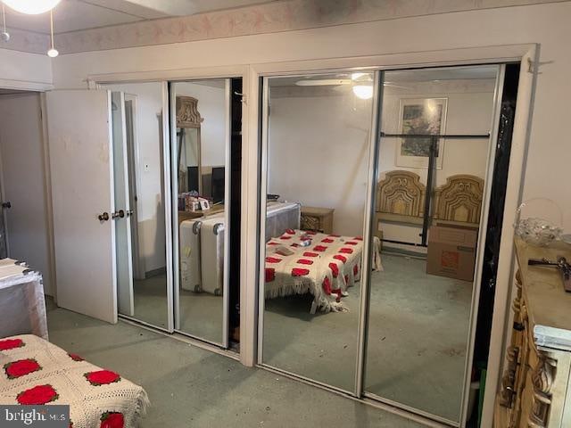 bedroom with concrete floors and two closets