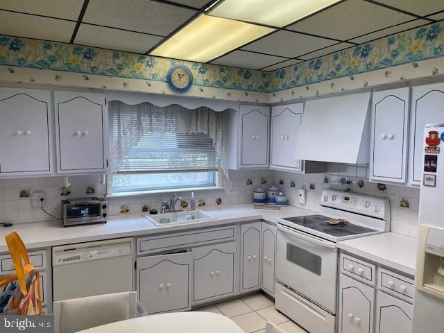 kitchen with white appliances, light tile flooring, backsplash, sink, and exhaust hood