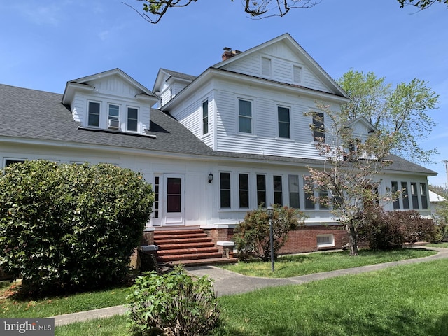 rear view of house featuring a lawn