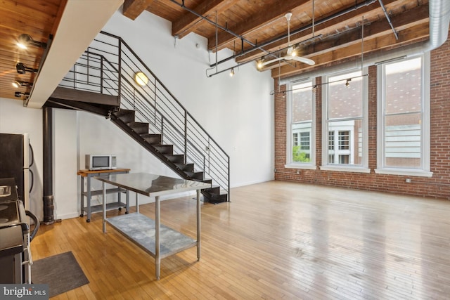 foyer entrance with beam ceiling, brick wall, wood ceiling, and hardwood / wood-style flooring