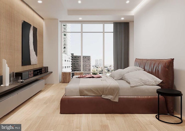 bedroom featuring light wood-type flooring, baseboard heating, and multiple windows