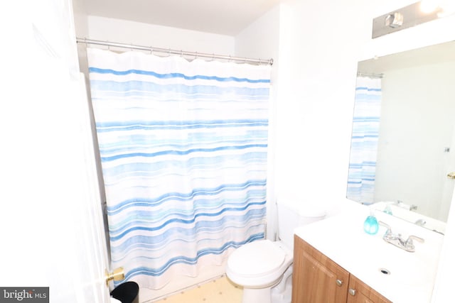 bathroom featuring tile flooring, vanity, and toilet