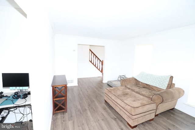 living room with hardwood / wood-style flooring and crown molding