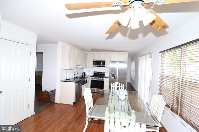 dining space with ceiling fan and dark wood-type flooring