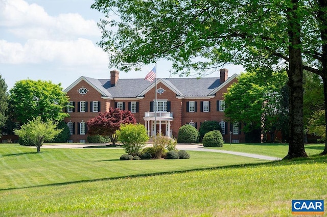 colonial inspired home featuring a front lawn