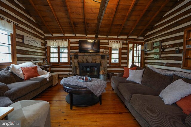 living room with a stone fireplace, vaulted ceiling with beams, wood ceiling, and wood-type flooring