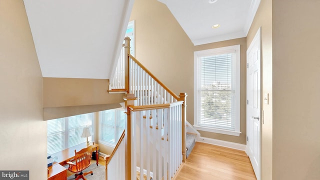 staircase with wood-type flooring and ornamental molding