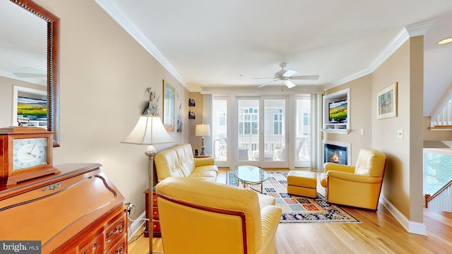 living area with light hardwood / wood-style flooring, ceiling fan, and ornamental molding