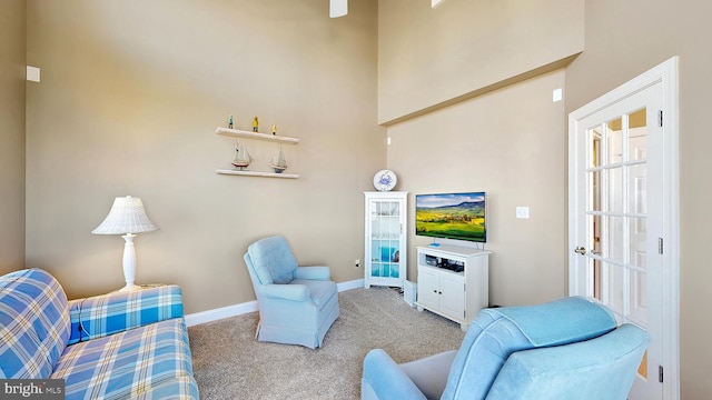 living room featuring a towering ceiling and carpet floors