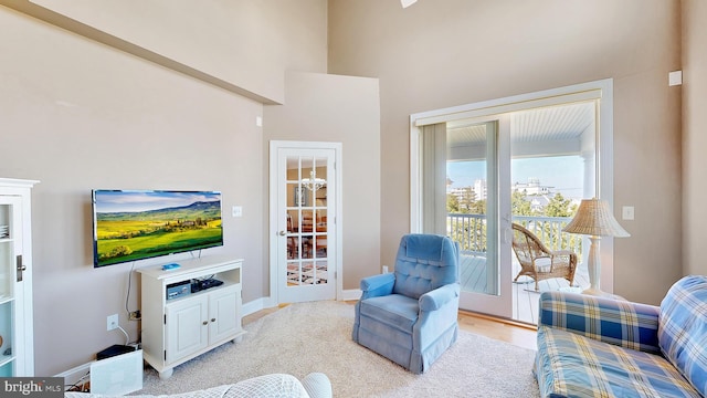 carpeted living room featuring a high ceiling