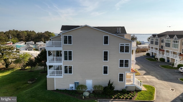 view of property exterior featuring a lawn and a water view