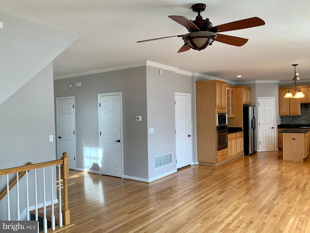 kitchen with stainless steel appliances, light wood-type flooring, tasteful backsplash, ceiling fan with notable chandelier, and hanging light fixtures