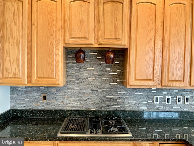 kitchen featuring dark stone counters, gas cooktop, and decorative backsplash