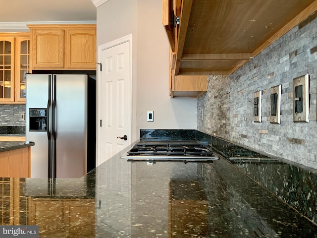 kitchen featuring stainless steel appliances, ornamental molding, tasteful backsplash, and dark stone counters