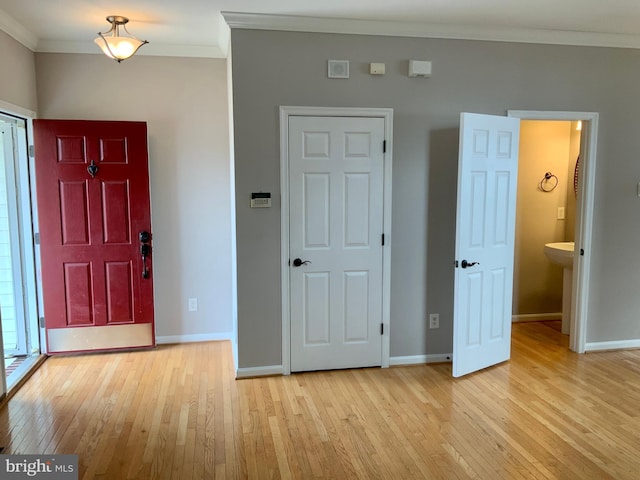 entrance foyer featuring ornamental molding and light wood-type flooring