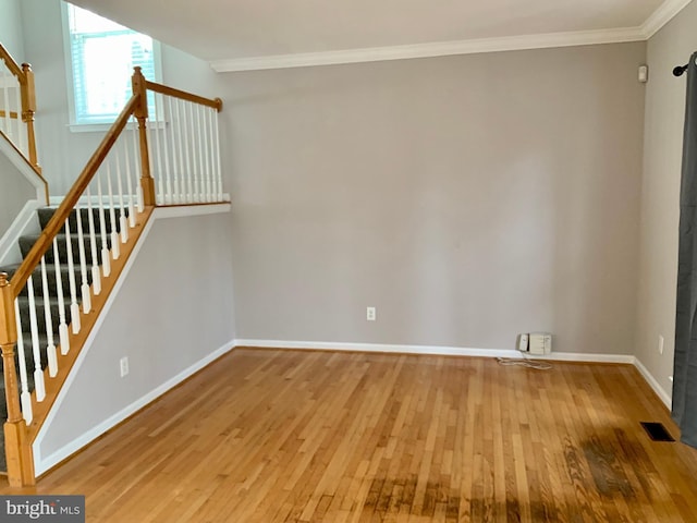 interior space with ornamental molding and hardwood / wood-style floors