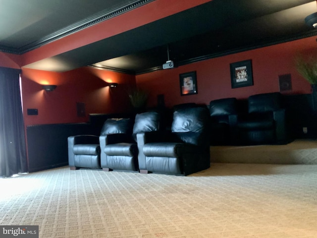 carpeted home theater room featuring ornamental molding