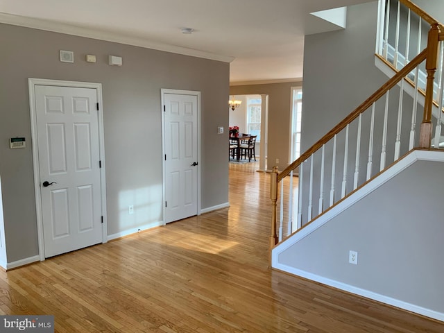 interior space featuring a notable chandelier, crown molding, and light hardwood / wood-style flooring