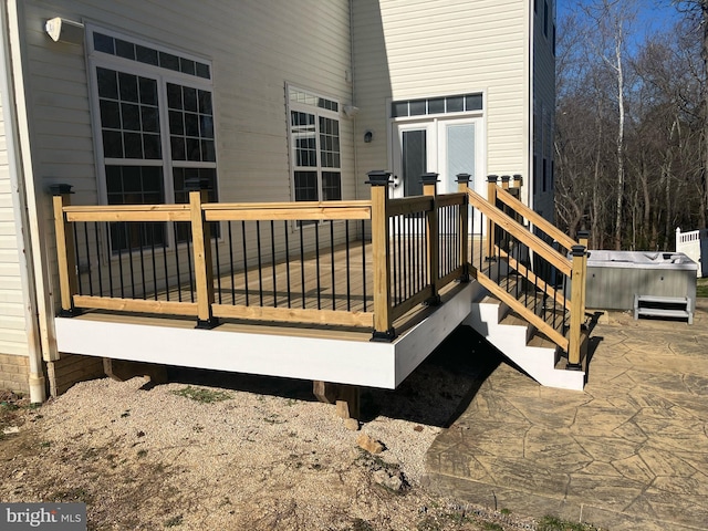 deck featuring a hot tub and a patio area