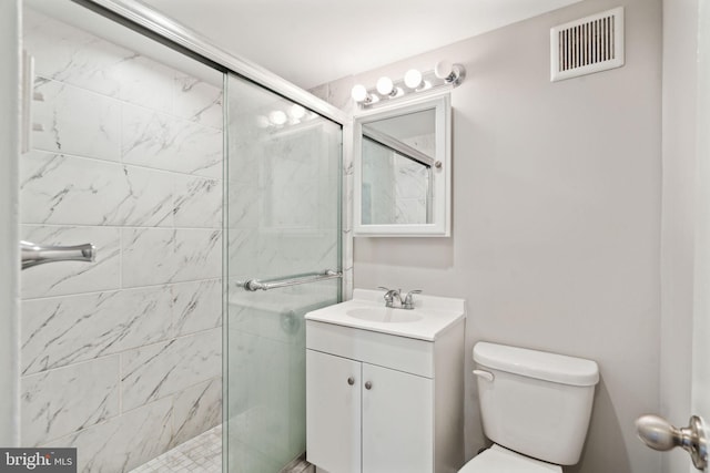 bathroom with vanity, toilet, and a shower with door