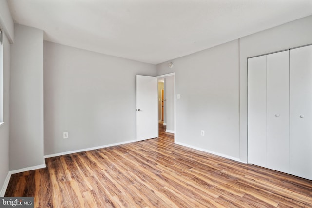 unfurnished bedroom featuring a closet and light wood-type flooring