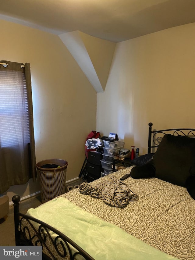 carpeted bedroom featuring lofted ceiling