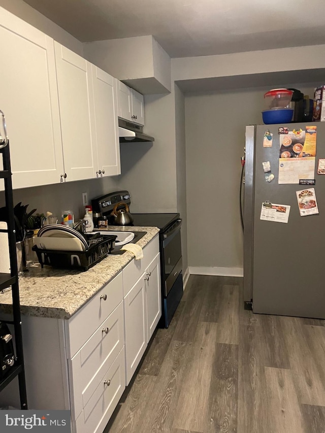 kitchen with wood-type flooring, white cabinetry, light stone counters, electric range, and stainless steel fridge