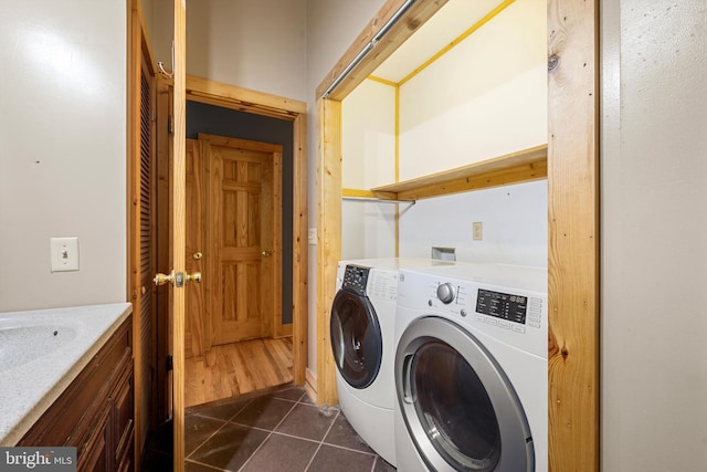 clothes washing area featuring dark tile patterned flooring and washing machine and clothes dryer