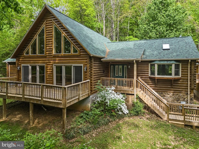 rear view of house featuring a wooden deck and french doors