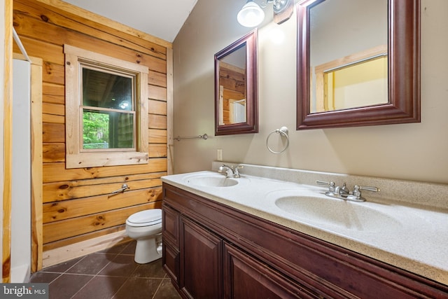 bathroom with wood walls, tile patterned flooring, vanity, and toilet