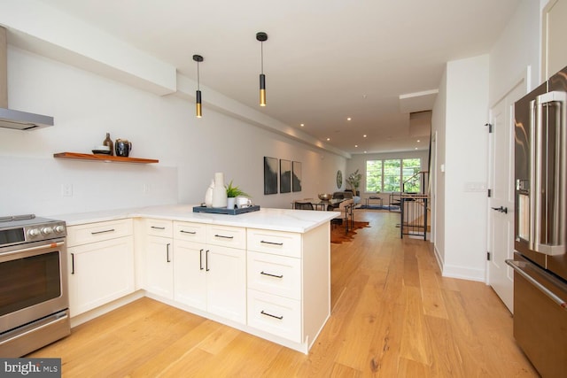 kitchen with decorative light fixtures, kitchen peninsula, white cabinetry, light hardwood / wood-style flooring, and appliances with stainless steel finishes