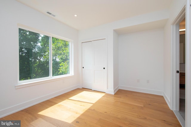 unfurnished bedroom with a closet and light hardwood / wood-style flooring