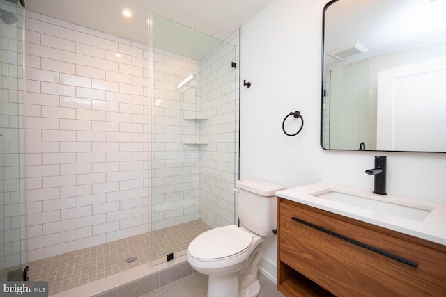 bathroom with toilet, tile patterned flooring, tiled shower, and vanity