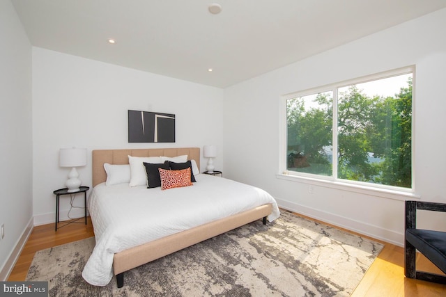 bedroom with light hardwood / wood-style flooring and multiple windows