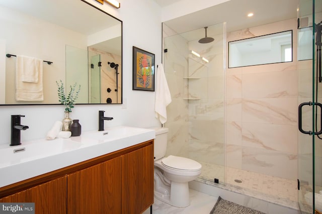 bathroom with walk in shower, vanity, and toilet